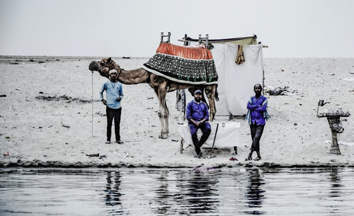 Drei Kamelführer mit Kamel am Ufer des Ganges, Varanasi Indien, Fine Art Dokumentarfotografie limitierte Edition.