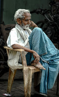 Mann in traditionellem Sari, sitzend am Straßenrand in Varanasi Indien, Fine Art Straßenfotografie limitierte Edition